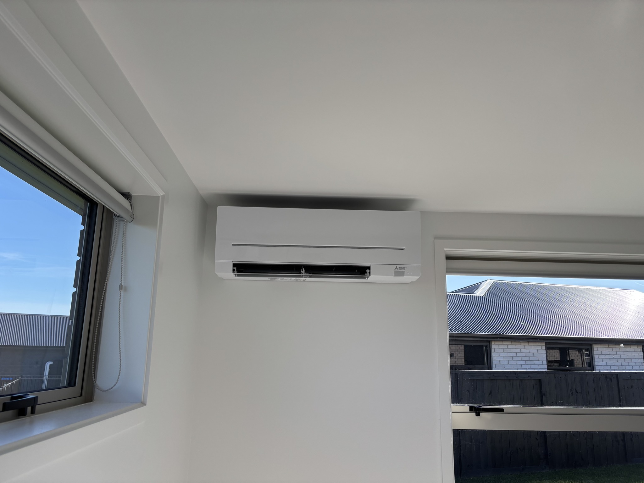 Indoor Mitsubishi Electric high wall heat pump installed in a bedroom