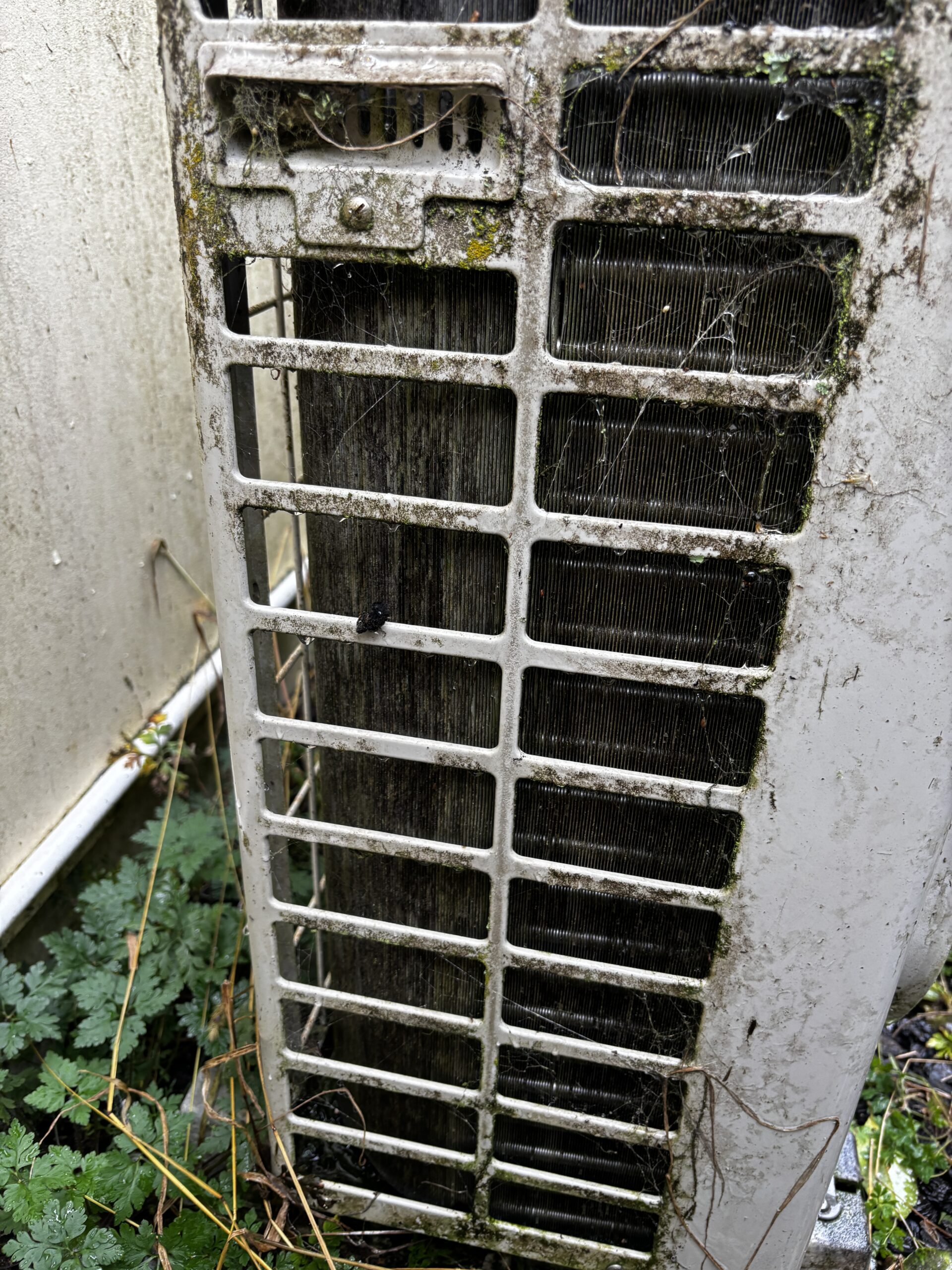 Close up of dirty blocked outdoor heat pump coil